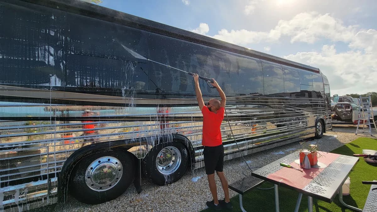 Leoserve crew member rinsing a luxury Prevost coach at a Florida Keys campground