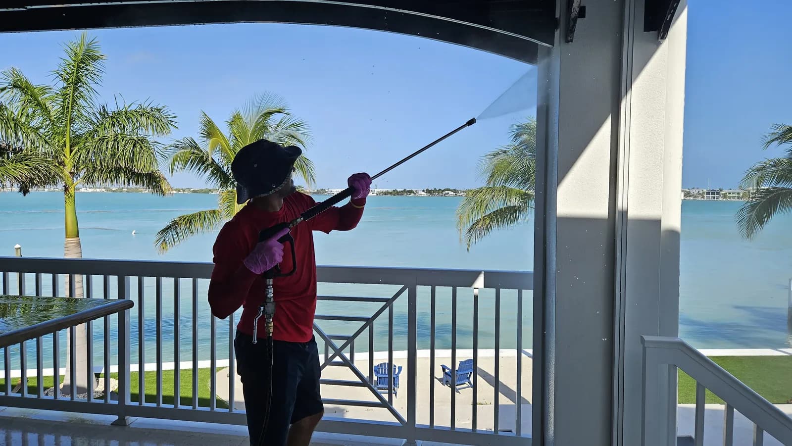 Leoserve technician soft-washing the exterior of a waterfront Florida Keys home