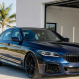 Professionally detailed dark blue sedan with a clean glossy paint finish outside a Florida Keys detailing bay