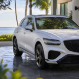 Glossy pearl-white luxury crossover parked at a clean Key West home after rain.